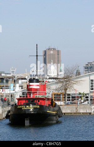 Ein Schlepper vor Anker in Montreals alten Hafen mit der Stadt im Hintergrund Stockfoto