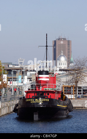 Ein Schlepper vor Anker in Montreals alten Hafen mit der Stadt im Hintergrund Stockfoto