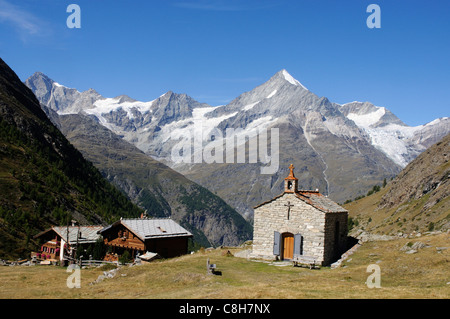 Eine kleine Kapelle und zwei Chalets im Wallis auf die Schweizer Alpen mit dem Weisshorn über hohe Stockfoto