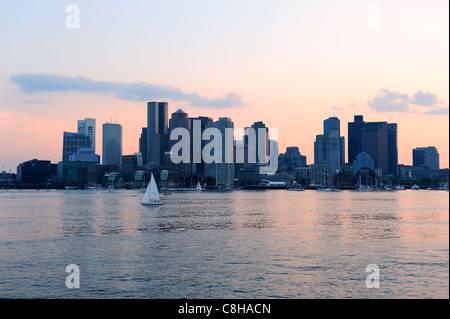 Die Innenstadt von Sonnenuntergang Skyline von Boston über Fluss mit Wolkenkratzern und Boot. Stockfoto