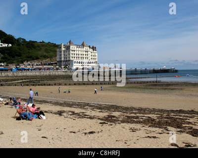 Leute sitzen direkt am Meer in größte Seebad LLandudno Wales North Wales Stockfoto