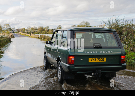 Mann fährt Range Rover durch überfluteten Landstraße in Nordirland auf Dienstag, 25. Oktober 2011. Stockfoto