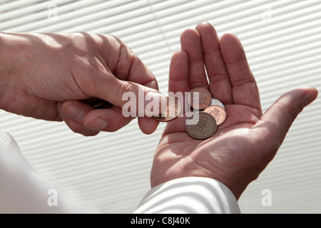 Leben mit einem knappen Budget, Münzen zählen die Pfennige, während einer Rezession die Runden zu kommen, Nahaufnahme der Hände Stockfoto