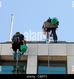 Nahaufnahme von Glasreiniger Arbeitnehmer Abseilen vom Dach nach unten von Office Block London England Großbritannien Stockfoto