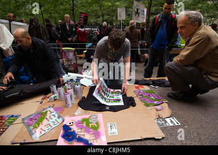 Occupy Wall Street Demonstrant Spritzlackierung "OCCUPY WALL STREET" auf einem schwarzen T-shirt innerhalb Zuccotti Park Stockfoto