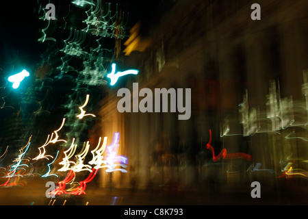 Verschwommene Nachtlichter der Stadt von einem Auto während der Fahrt. Stockfoto