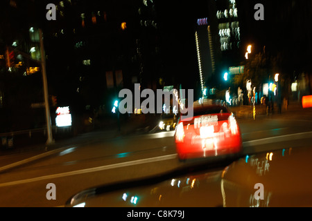 Verschwommene Nachtlichter der Stadt von einem Auto während der Fahrt. Stockfoto