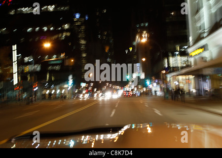 Verschwommene Nachtlichter der Stadt von einem Auto während der Fahrt. Stockfoto