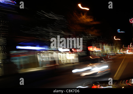 Verschwommene Nachtlichter der Stadt von einem Auto während der Fahrt. Stockfoto