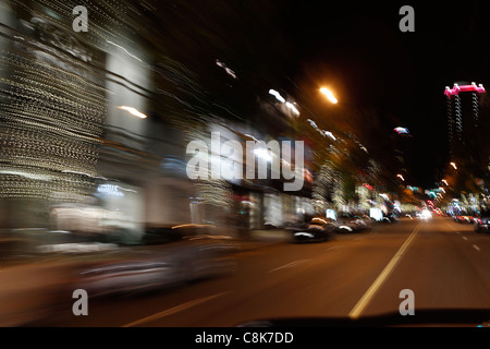 Verschwommene Nachtlichter der Stadt von einem Auto während der Fahrt. Stockfoto