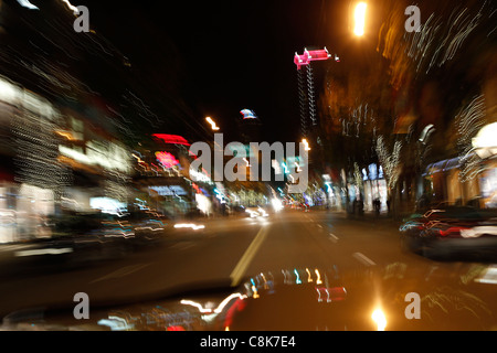 Verschwommene Nachtlichter der Stadt von einem Auto während der Fahrt. Stockfoto