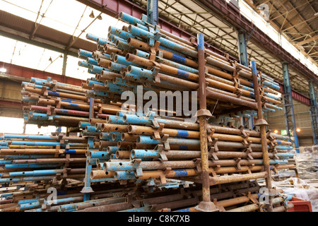 Haufen von gebrauchten Gerüststangen in einer alten Fabrik Lager Einheit Belfast Nordirland Vereinigtes Königreich gespeichert. Stockfoto