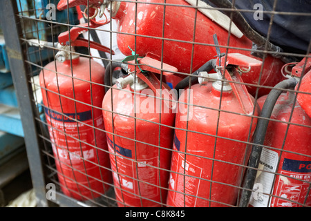 Haufen von Feuerlöschern in einer alten Fabrik Lager Einheit Belfast Nordirland Vereinigtes Königreich. Stockfoto