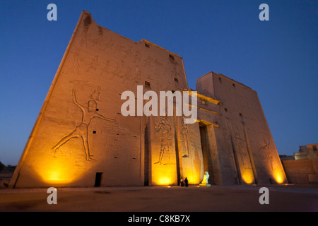 Die Statue des Horus von Behedet bei Sonnenuntergang auf dem Vorplatz am Eingang zu den ersten Pylon, Edfu Tempel, Edfu Oberägypten Stockfoto