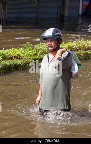 Motorradfahrer Wadeing durch Hochwasser, Bangkok, Thailand Stockfoto