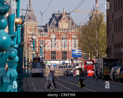 Amsterdam Hauptbahnhof mit der Straßenbahn, Busse und Menschen Damrak Straße zu überqueren. die Niederlande Stockfoto