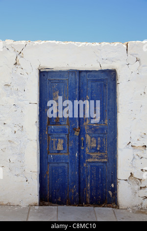 Die alte Mauer und blau Holztür. Oia (Ia), Santorini (Thira), Kykladen, Ägäis, Griechenland, Europa. Stockfoto