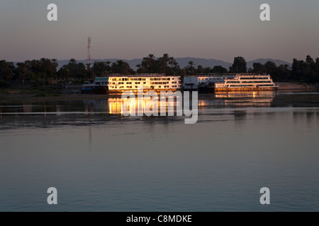 Nil-Kreuzfahrt Boote vertäut am Steg reflektieren den goldenen Glanz der späten Abendsonne, Luxor, Ägypten, Afrika Stockfoto