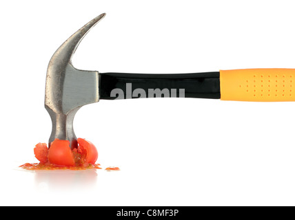 Gelbe Hammer zerquetscht Red Tomato isoliert auf weiss Stockfoto