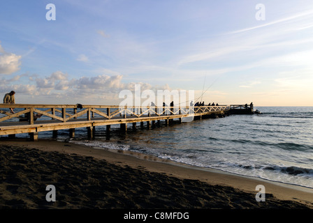 Menschen, die Angeln von einem hölzernen Pier in Ostia - Rom, Italien Stockfoto