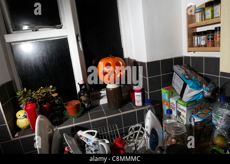 Ein Halloween-Kürbis, abgebildet in einer chaotischen Küche in Hove, East Sussex, UK. Stockfoto