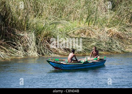 Zwei jungen blau lackierten Angeln Rudern auf dem Fluss Nil Ägypten mit einem Reed-Bank im Hintergrund Stockfoto