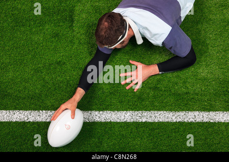 Obenliegende Foto ein Rugby-Spieler erstreckt sich über die Linie, einen Versuch mit einer Hand auf den ball zu erzielen. Stockfoto