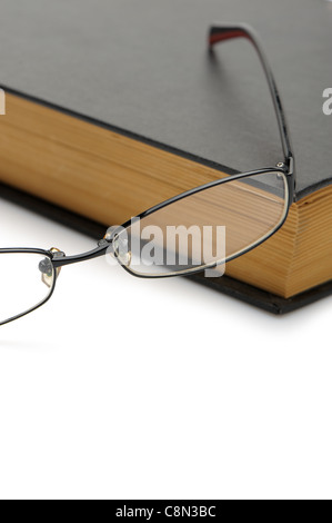 Brille auf dem alten dicken Buch. Isoliert auf weißem Hintergrund Stockfoto