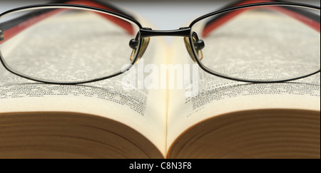 Brille auf dem alten dicken Buch. Ein Foto close up Stockfoto