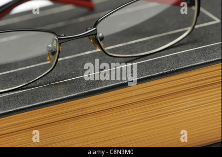 Brille auf dem alten dicken Buch. Ein Foto close up Stockfoto