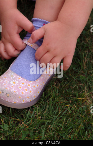 Nahaufnahme eines kleinen Mädchens, indem ihr die Schuhe draußen Stockfoto