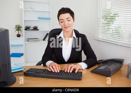 Ernsthafte Sekretär auf ihrer Tastatur tippen Stockfoto