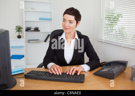 Charmante Sekretärin auf ihrer Tastatur tippen Stockfoto