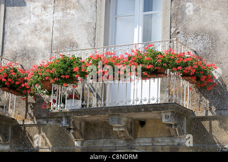 Italien, Sizilien, Novara di Sicilia, Balkon mit roten Geranien in Balkonkästen Stockfoto
