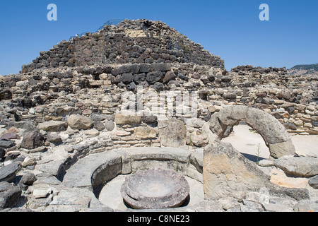 Italien, Sardinien, Nuraghe Su Nuraxi, Blick auf die Reste der nuragischen Dorf mit Schleifstein im Vordergrund Stockfoto