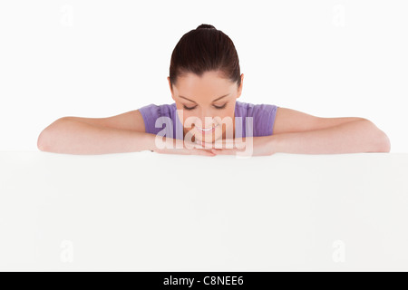 Schöne Frau posiert hinter einer Plakatwand stehen Stockfoto