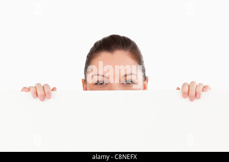 Porträt einer schönen Frau posiert hinter einer Plakatwand stehen Stockfoto