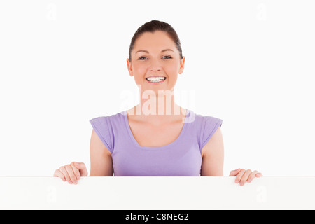 Porträt einer charmanten Frau posiert hinter einer Plakatwand stehen Stockfoto