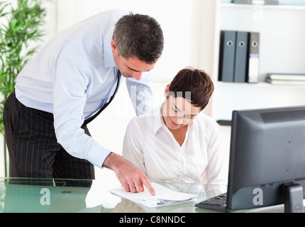 Businessmanager zeigt etwas an einem Dokument zu seiner Sekretärin Stockfoto
