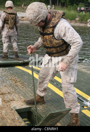 MARINE CORPS BASE CAMP LEJEUNE, N.C. - Sgt. Joshua L. Currie, eine Bekämpfung der Ingenieur mit 8 Egineer Support Battalion, 2nd Marine Logistik Gruppe, nutzt eine Hydraulikpumpe die Rampe eines verbesserten Float Brücke während einer Operation an Bord Marine Corps Base Camp Lejeune Juli 14, 2011 zu führen. Ziel der Mission war 10 M1A1 Abrams Kampfpanzer und eine M88 Hercules schwere Ausrüstung Recovery Fahrzeug an den jährlichen Schießwesen Qualifikationen zur Fähre für 2. Tank Battalion, 2nd Marine Division. Stockfoto