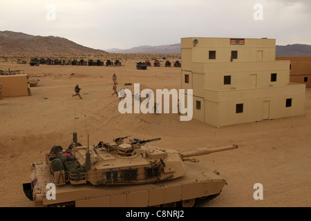 Ein M1A1 Abrams-Panzer mit Company A, 1. Panzerbataillon, unterstützt die 1. Panzerbataillone der 1. Leichten Panzeraufklärungsbataillone, während die Infanterie-Marines während der klaren Phase des Enhanced Mojave Viper Trainings im Bereich 220 5. September 2011 auf das nächste Ziel zulaufen. Stockfoto