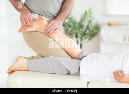 Der Masseur massiert Frau Fuß Stockfoto