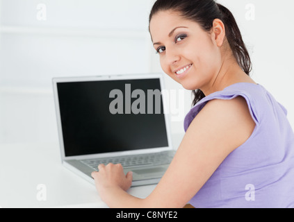 Süße junge Frau sitzt mit laptop Stockfoto