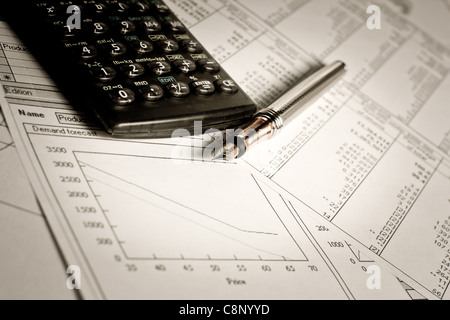 Finanz-Charts und Tabellen mit Taschenrechner und Stift auf dem Tisch liegen Stockfoto