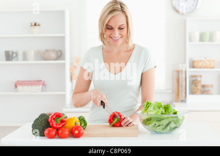 Lächelnde Frau Schneiden von Gemüse Stockfoto