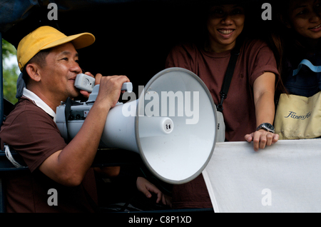 Ein Thailänder spricht auf einem Megaphon, als thailändische Flüchtlinge am 28th. Oktober 2011 auf einem Katastrophenhilfe-LKW, Phahon Yothin Road, Bangkok, Thailand, aus der Flut fliehen. Thailand erlebt seine schlimmsten Überschwemmungen seit 50 Jahren. © Kraig Lieb Stockfoto