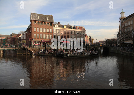 Mit Blick auf die Kreuzung der Oude und Nieuwe Rijn Flüsse im Zentrum des alten Leiden mit schwimmenden Restaurant Holland Niederlande Stockfoto