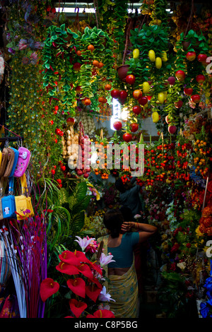 in einem beliebten Markt in in Neu-Delhi wählt eine Frau welche Kunststoff Blumen kaufen Stockfoto