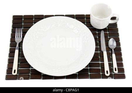 Speiseteller, strukturierte weiße China mit Trauben und Tomaten Design über einem dunklen Holz Tischset. Stockfoto