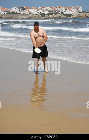 ein dicker Mann spielen Beach-Tennis am Strand Stockfoto